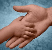 Babyhand berührt erwachsene Hand